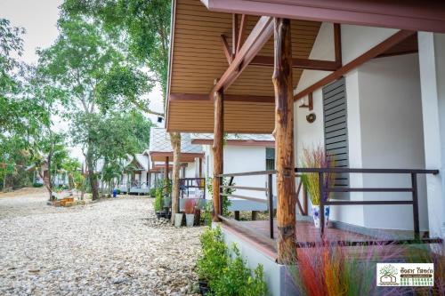 una casa con detalles de madera y una pasarela al aire libre en Ingtarn Ressort At thasala en Ban Nai Thung