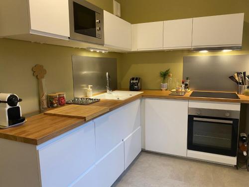 a kitchen with white cabinets and a counter top at Spacieux logement au pied du Vercors in Saint-Jean-en-Royans