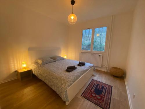 a bedroom with a bed and two lamps and a window at Spacieux logement au pied du Vercors in Saint-Jean-en-Royans