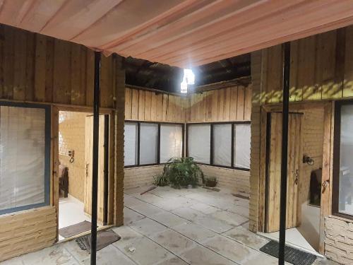 an empty room with wooden walls and windows at Varenya Agro Resort in Kolvan