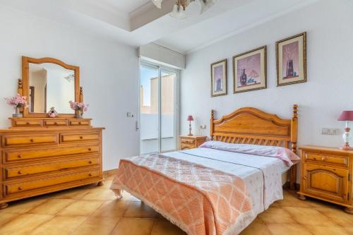 a bedroom with a bed and a dresser and a mirror at Mar Báltico in Torrevieja