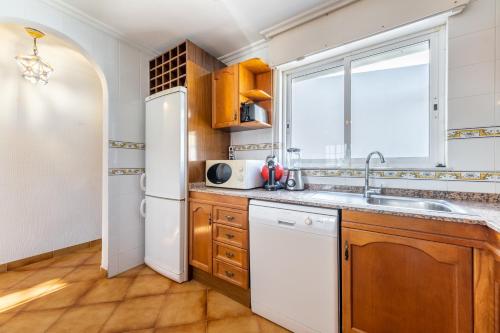 a kitchen with a sink and a refrigerator at Mar Báltico in Torrevieja