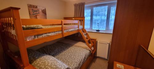 two bunk beds in a small room with a window at 9 Wheal Ramoth, Atlantic bay in Perranporth