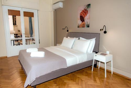 een slaapkamer met een groot wit bed en een tafel bij Plaka Apartment in Athene