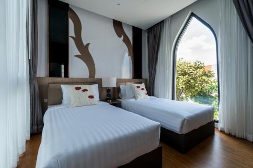 dwa łóżka w pokoju z oknem w obiekcie Panora villa by VillaCarte w mieście Surin Beach