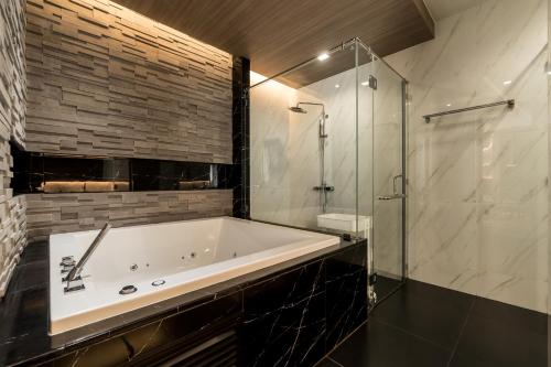 W łazience znajduje się wanna i przeszklony prysznic. w obiekcie Panora villa by VillaCarte w mieście Surin Beach