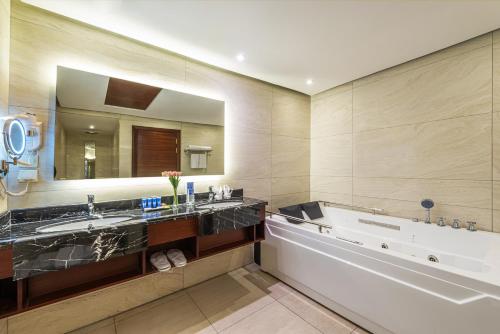 فندق بلو دايموند جدة في جدة: حمام به مغسلتين ومرآة كبيرة
