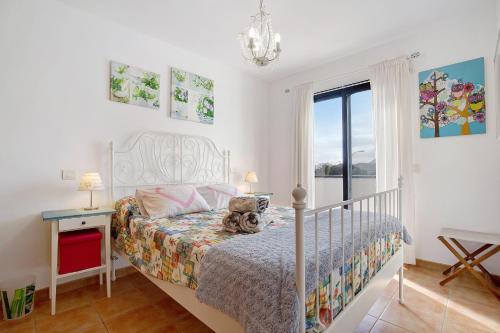 a bedroom with a bed and a desk and a window at La Casa Blanca in Corralejo