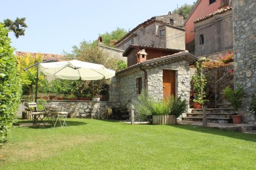 a garden with an umbrella and a table and chairs at Il Borgo Ospitale - Albergo Diffuso in Rotonda
