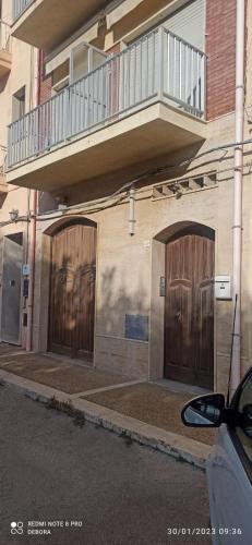 two wooden doors on the side of a building at Mare Azzurro Appartamento in Sciacca