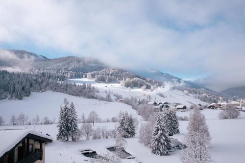 a snow covered mountain with a house and trees at Hotel Guesthouse Dalnig in Bad Kleinkirchheim