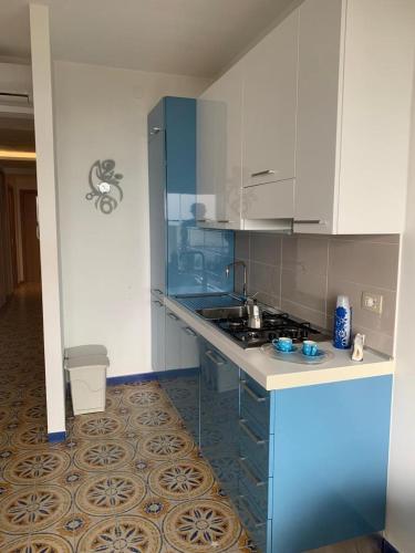 a kitchen with blue and white cabinets and a sink at Mare Azzurro Appartamento in Sciacca