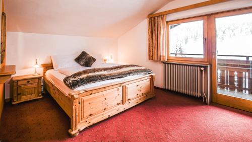 een slaapkamer met een groot bed en een raam bij Hotel Guesthouse Dalnig in Bad Kleinkirchheim