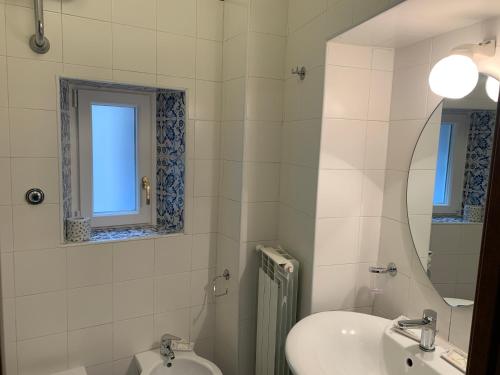 a bathroom with a sink and a toilet and a mirror at Folle Città B&B in Naples