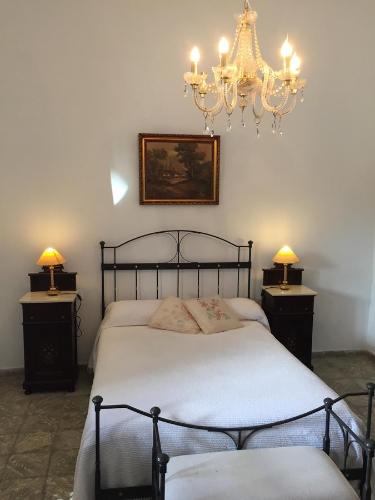 a bedroom with a bed with a chandelier and two night stands at GBH Casa Quintana in La Oliva