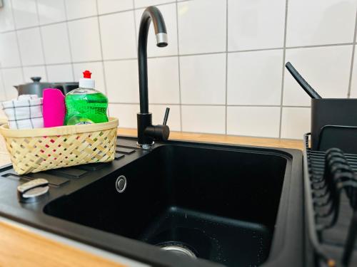 a kitchen sink with a faucet and a basket of dishes at Apartments Dombergblick - Suhl, Stadtmitte in Suhl
