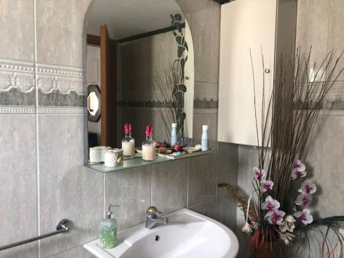 uma casa de banho com um lavatório e um espelho em La maisonnette Villa Katerina em Krionérion
