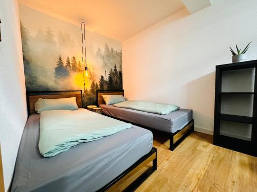 Habitación con 2 camas y una pintura en la pared. en Apartments Dombergblick - Suhl, Stadtmitte, en Suhl