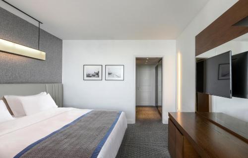 a hotel room with a bed and a flat screen tv at Makedonia Palace in Thessaloniki