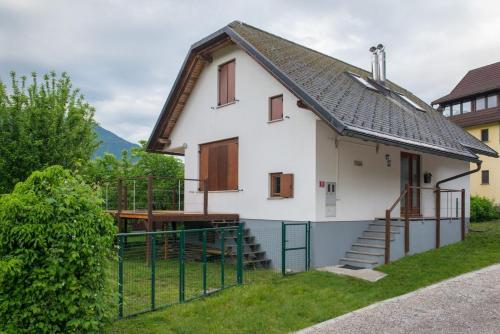 a white house with a porch and a fence at House Jelenko in Bovec