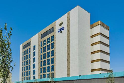 een hoog wit gebouw met een logo erop bij Hilton Garden Inn Samarkand Sogd in Samarkand