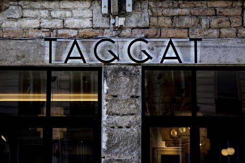 un panneau à l'avant d'un magasin dans l'établissement Hôtel Taggât, à Lyon