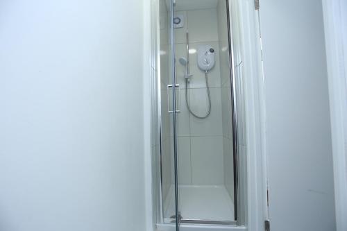 y baño con ducha y puerta de cristal. en Abbeywood Station House London, en Londres