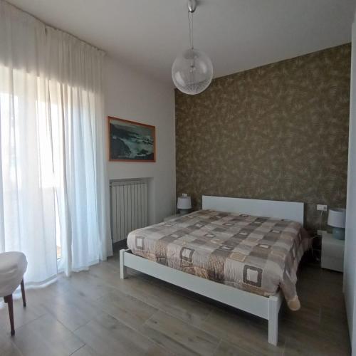 a bedroom with a bed and a large window at Piazza Mazzini 21 in Loano