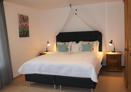 a bedroom with a large bed and two lamps at Landhotel Hubertus in Unterelsbach