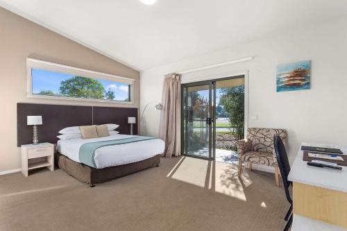 a bedroom with a bed and a sliding glass door at Quality Hotel Point Cook in Point Cook
