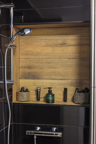 a bathroom with a shelf with bottles and glasses at Ioana Residence Bucovina in Câmpulung Moldovenesc