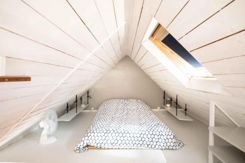 Schlafzimmer im Dachgeschoss mit einem Bett und einem Dachfenster in der Unterkunft La Petite Maison De Papaye in Le Palais