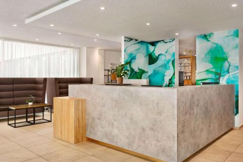 a lobby with a reception desk in a building at Wyndham Garden Munich Messe in Munich