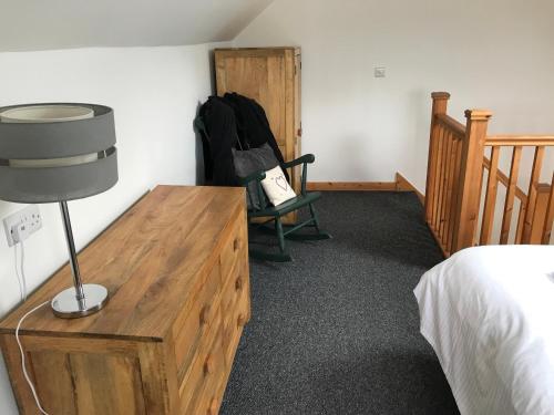 a bedroom with a bed and a desk with a lamp at The Stables and Granary at Shawbroom Farm in Cheswardine