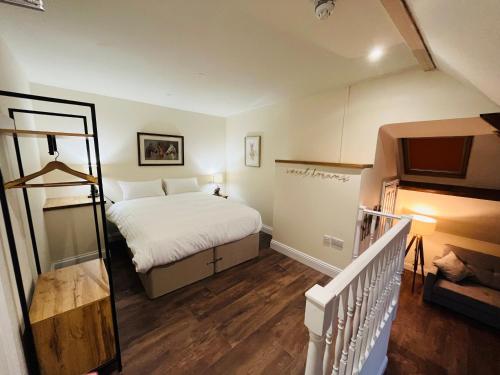 a small bedroom with a bed and a staircase at The Forester in Shaftesbury