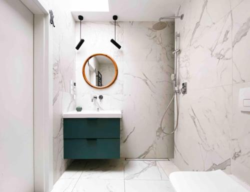 bagno con specchio e mobile con lavabo verde. di Apartament Loft 80m2 w sercu miasta a Bydgoszcz