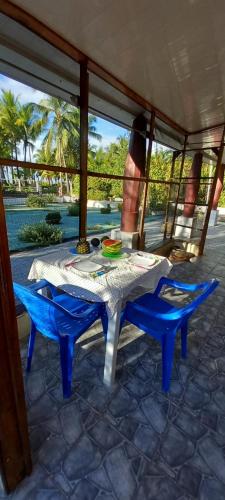 a table and two blue chairs on a patio at chambre indépendante chez l'habitant in Parrita