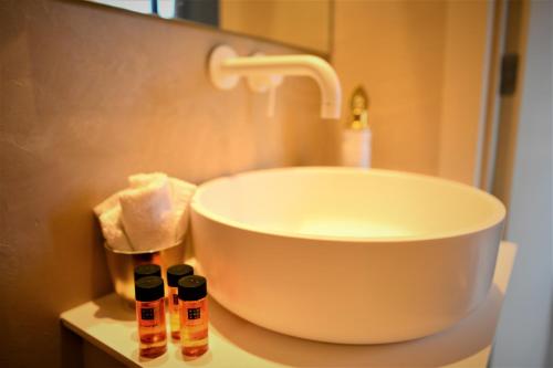 a bathroom with a sink and three bottles on a counter at Kyoto Suites - Center Antwerp! in Antwerp