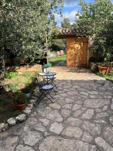 a stone patio with a table and a gate at Masiadenjust in Rojals
