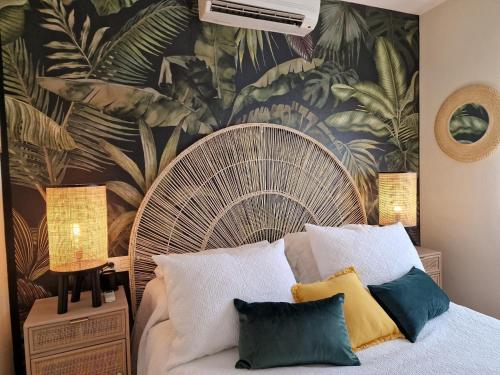 1 dormitorio con 1 cama grande y papel pintado tropical en Casa Rural El Canto Del Agua, en Malpartida de Plasencia