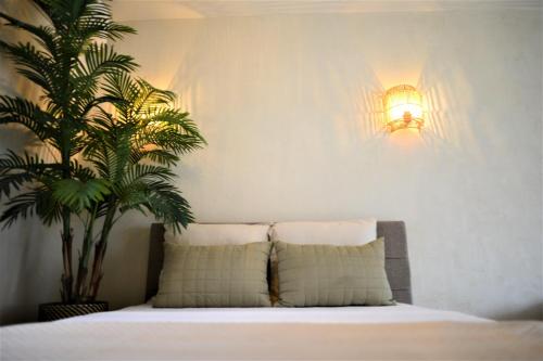 - une chambre avec un lit avec une plante et une lumière dans l'établissement Kyoto Suites - Center Antwerp!, à Anvers