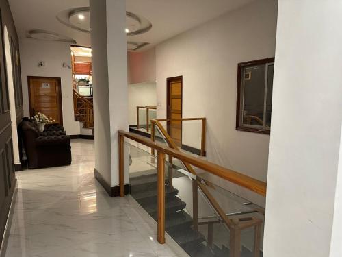 a hallway with a staircase and a living room at Lawrence View Hotel, Lahore in Lahore