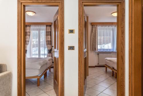 a room with two beds and a room with two windows at Cima Dodici A Parte in Soraga