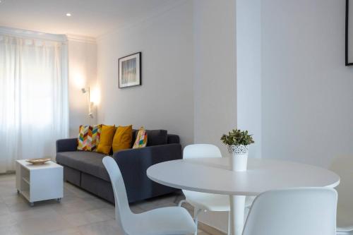 a living room with a white table and a couch at Apartamentos Los Cantaros in El Puerto de Santa María
