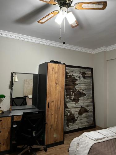 Schlafzimmer mit einem Deckenventilator und einem Schreibtisch mit einem TV in der Unterkunft Private Room in Istanbul #33 in Arnavutköy