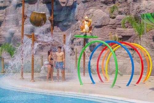 two people standing in front of a water fountain at a resort at Orka World Hotel & Aquapark in Oludeniz