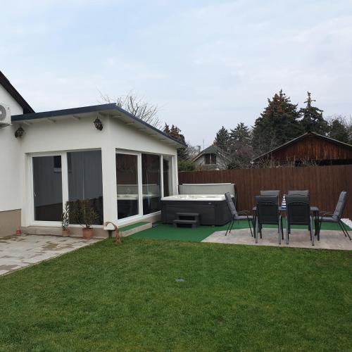 a backyard with chairs and a grill and a house at MaZso vendégház Balatonakarattya in Balatonakarattya