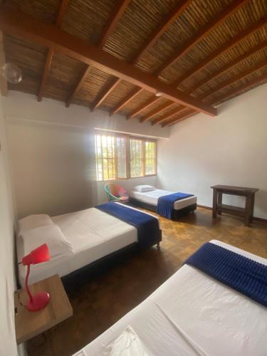 a bedroom with two beds and a wooden ceiling at Yolo Hostel Medellin in Medellín