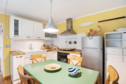 a kitchen with a table and a refrigerator at Il giardino di Belgirate in Belgirate