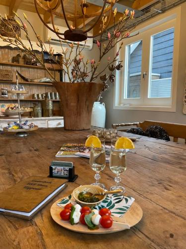 a table with a plate of food and glasses of wine at Bed & Breakfast Hoeve Happiness in Voorthuizen